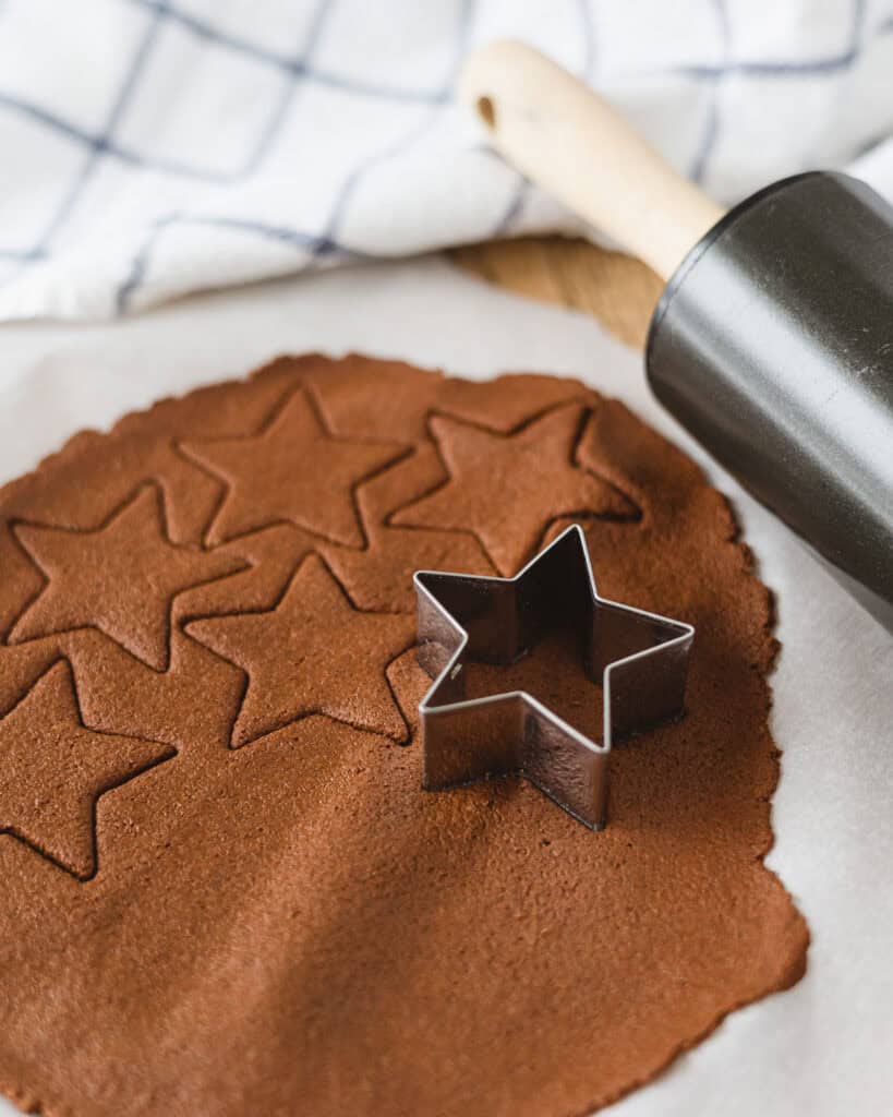 Star cookie cutter cutting cinnamon applesauce clay into star shapes.