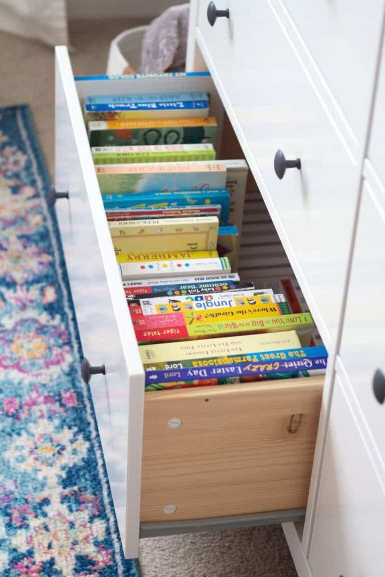 An open drawer of a dresser filled with children's books.