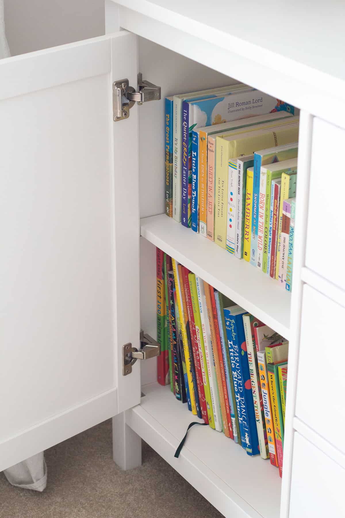 An open cupboard filled with children's books.