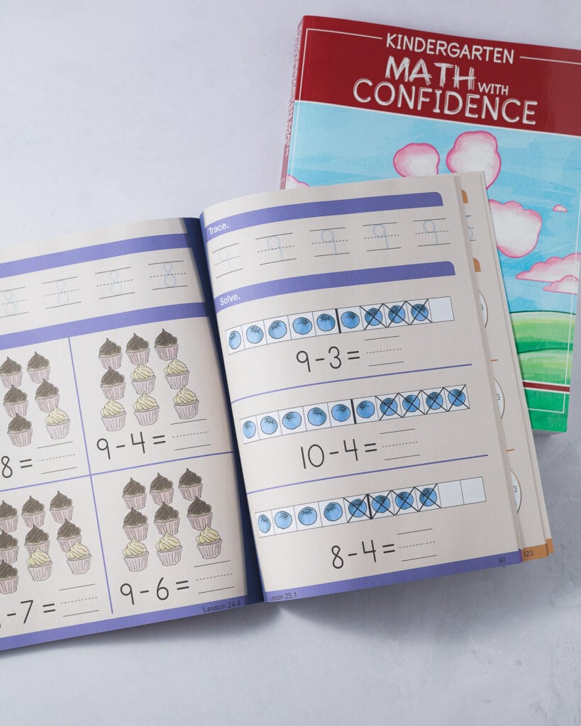 Math with Confidence Kindergarten workbook pages showing a variety of subtraction problems using cupcakes on one page and blueberries inside a ten-frame on the other page.