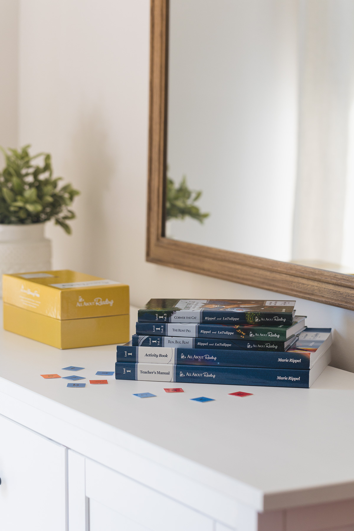 All About Reading books arranged on a white dresser.