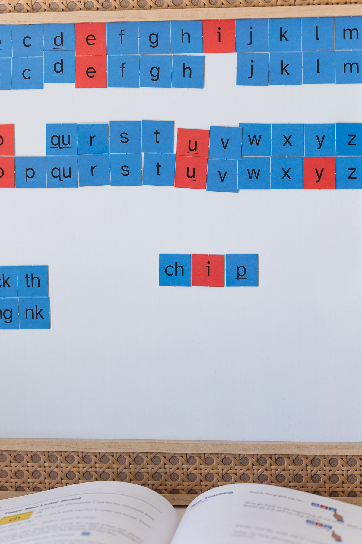 Using red and blue magnet tiles on a white board to practice phonics and reading.